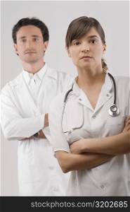 Portrait of a female and a male doctor standing with their arms crossed