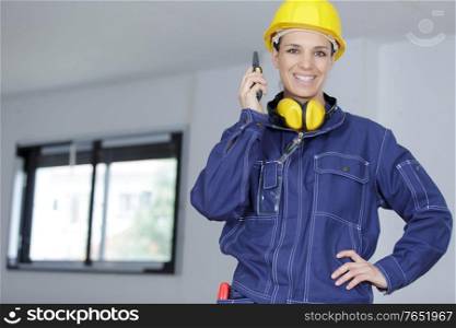 portrait of a female builder communicating by walkie talkie