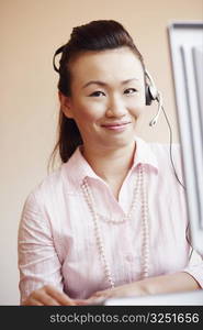 Portrait of a female customer service representative talking on a headset and smiling