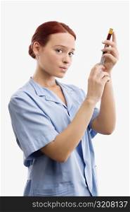 Portrait of a female doctor filling a syringe from a vial