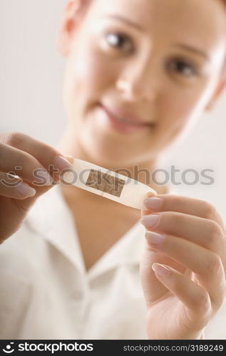 Portrait of a female doctor holding a bandage