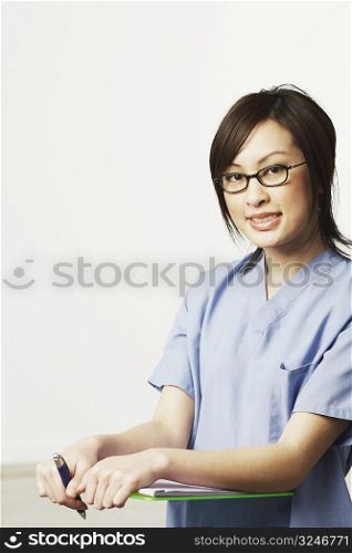 Portrait of a female doctor holding a clip board and a pen