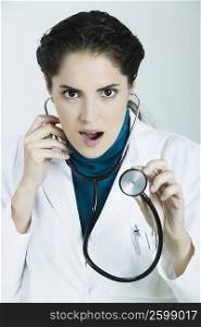Portrait of a female doctor holding a stethoscope and making a face