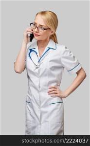 Portrait of a female doctor or nurse talking on the mobile phone.. Portrait of a female doctor or nurse talking on the mobile phone