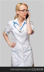 Portrait of a female doctor or nurse talking on the mobile phone.. Portrait of a female doctor or nurse talking on the mobile phone