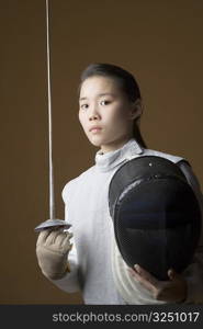 Portrait of a female fencer holding a sword and a fencing mask