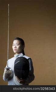 Portrait of a female fencer holding a sword and a fencing mask