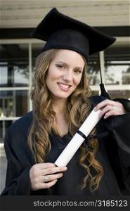 Portrait of a female graduate holding her degree and smiling