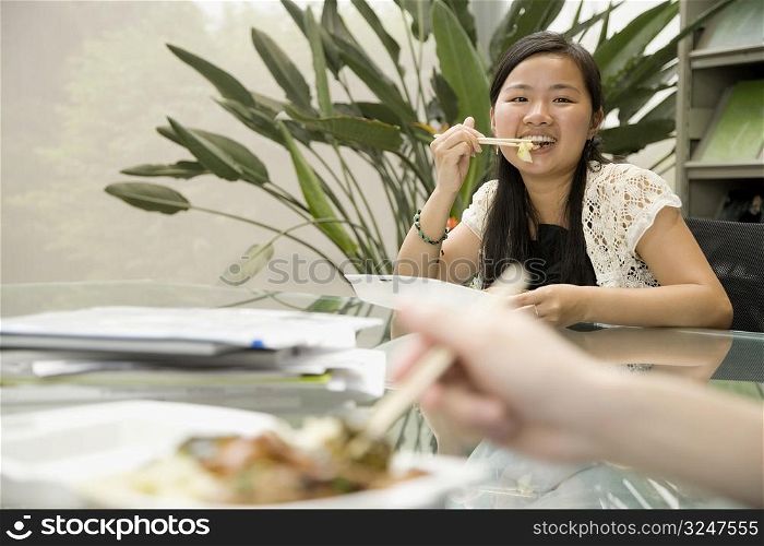 Portrait of a female office worker having lunch and smiling