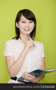 Portrait of a female office worker holding a file and smiling