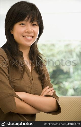 Portrait of a female office worker standing with her arms crossed in an office