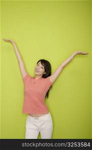 Portrait of a female office worker standing with her arms raised and smiling