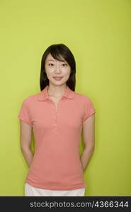 Portrait of a female office worker standing with her hands behind her back