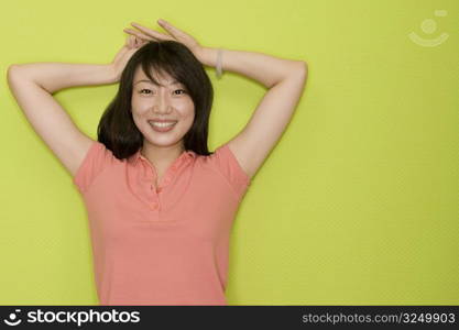 Portrait of a female office worker standing with her hands on her head and smiling