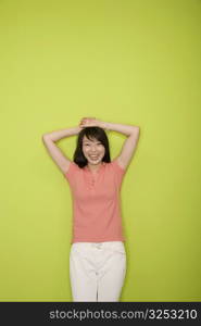 Portrait of a female office worker standing with her hands on her head and smiling