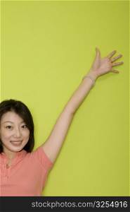 Portrait of a female office worker with her hand raised and smiling