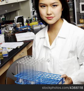 Portrait of a female pharmacist holding test tubes on a rack