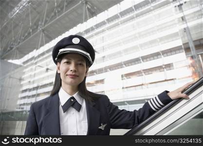 Portrait of a female pilot standing on an escalator