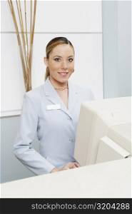 Portrait of a female receptionist in front of a computer