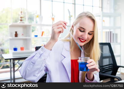 portrait of a female researcher carrying out research in a chemistry lab scientist holding test tube with sample in Laboratory analysis background