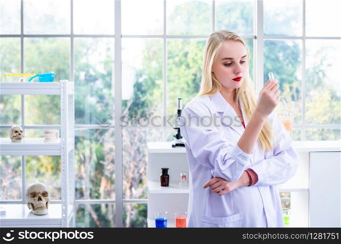 portrait of a female researcher carrying out research in a chemistry lab scientist holding test tube with sample in Laboratory analysis background