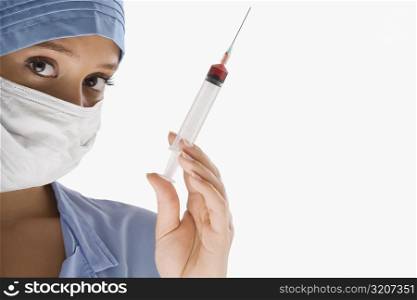 Portrait of a female surgeon holding a syringe