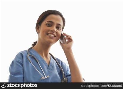 Portrait of a female surgeon using cell phone isolated over white background