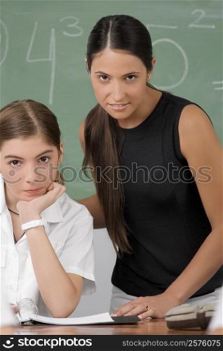 Portrait of a female teacher with a schoolgirl in a classroom
