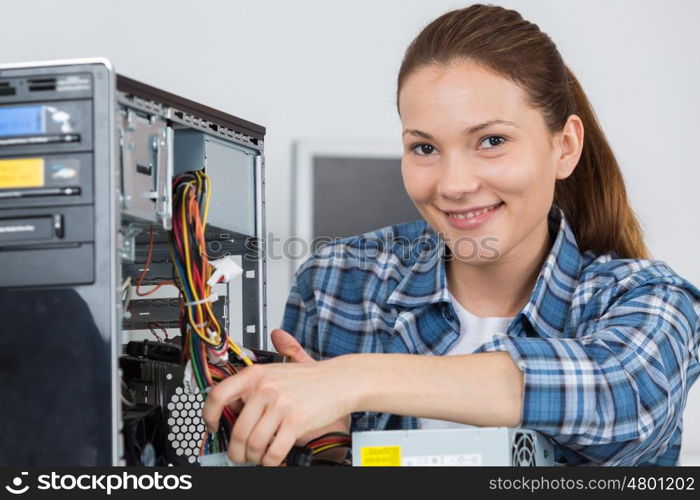 portrait of a female technician fixing computer with her colleague