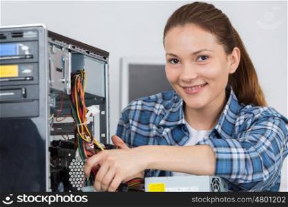 portrait of a female technician fixing computer with her colleague