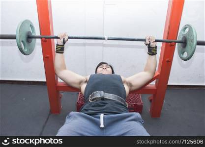 Portrait of a fit lean young asian man exercising in a gym.