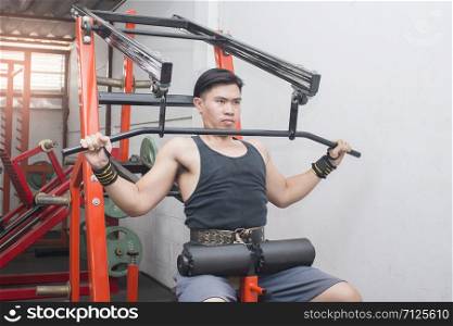 Portrait of a fit lean young asian man exercising in a gym.