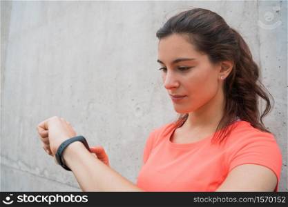 Portrait of a fitness woman checking time on her smart watch. Sport and healthy lifestyle concept.
