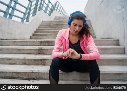 Portrait of a fitness woman monitoring her progress on smart watch. Sport and healthy lifestyle concept.