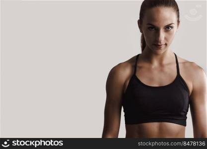 Portrait of a fitness woman posing against a gray background