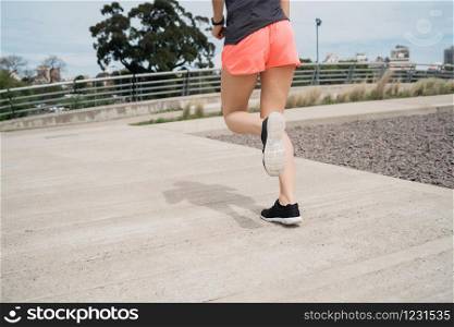 Portrait of a fitness woman running outdoors in the street. Sport and healthy lifestyle.