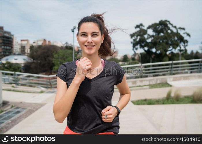 Portrait of a fitness woman running outdoors in the street. Sport and healthy lifestyle.