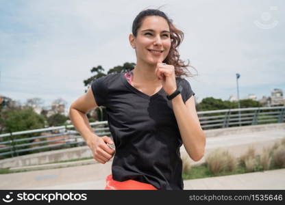 Portrait of a fitness woman running outdoors in the street. Sport and healthy lifestyle.