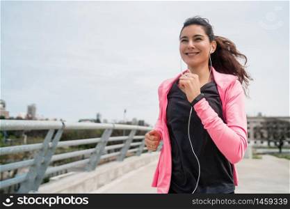 Portrait of a fitness woman running outdoors in the street. Sport and healthy lifestyle concept.