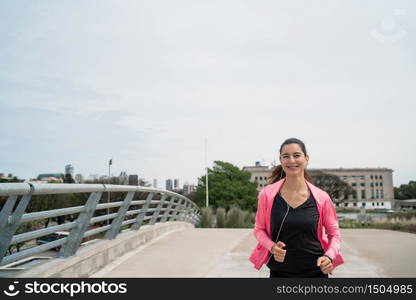 Portrait of a fitness woman running outdoors in the street. Sport and healthy lifestyle concept.