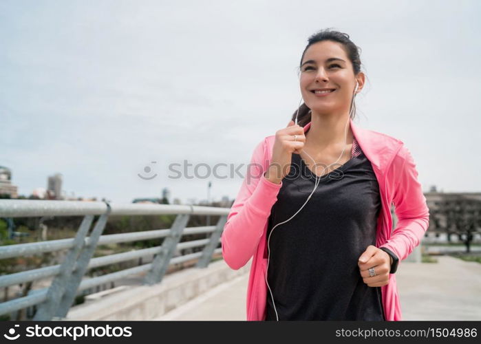 Portrait of a fitness woman running outdoors in the street. Sport and healthy lifestyle concept.