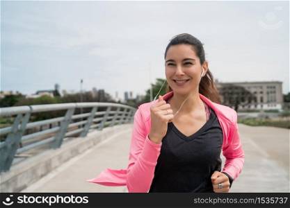 Portrait of a fitness woman running outdoors in the street. Sport and healthy lifestyle concept.