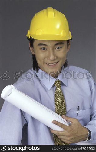 Portrait of a foreman wearing a hardhat holding a blueprint