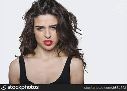Portrait of a frustrated young female against gray background
