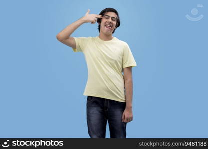Portrait of a funny teenage boy gesturing against blue background