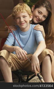 Portrait of a girl and her brother holding a fishing rod