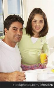 Portrait of a girl and her father holding a glass of juice