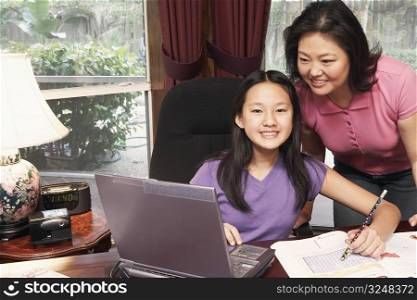 Portrait of a girl and her mother in front of a laptop