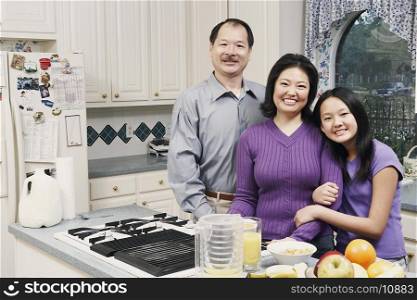 Portrait of a girl and her parents in the kitchen