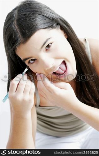 Portrait of a girl applying eyeshadow on her eyes